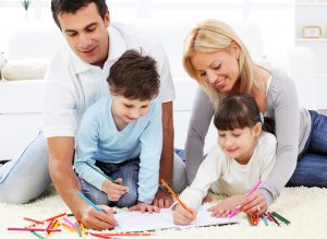 Happy family. Parent with children drawing in colorful pencils.