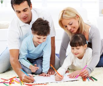 Happy family. Parent with children drawing in colorful pencils.